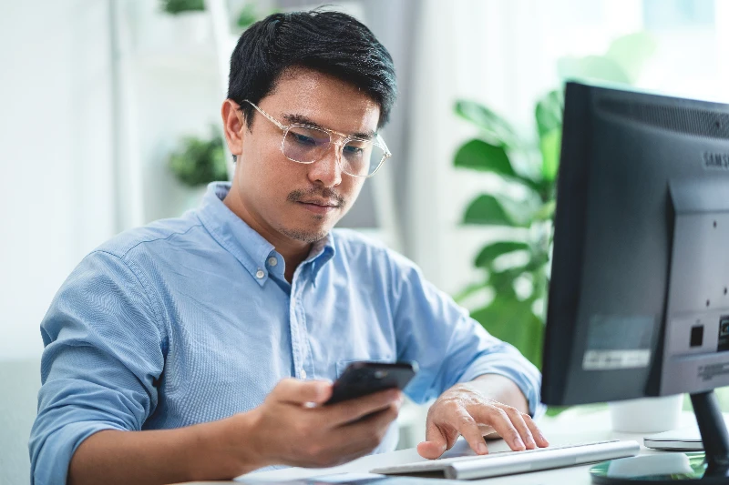 A man wearing glasses is sitting at a desk